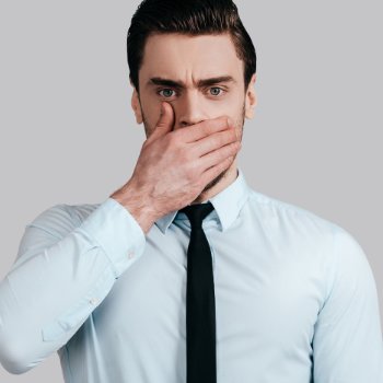 Stressed handsome businessman covering his mouth with his hand