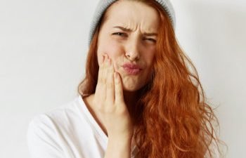 redhead girl suffering from toothache