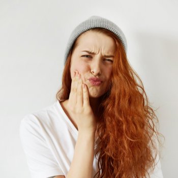 redhead girl suffering from toothache